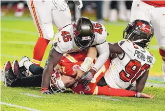  ?? GREGORY BULL/ASSOCIATED PRESS ?? Tampa Bay defenders Devin White (45) and Jason Pierre-Paul lie atop Patrick Mahomes after tackling the Kansas City quarterbac­k during the second half of Super Bowl LV in Tampa, Florida. The Buccaneers routed the Chiefs, 31-9.