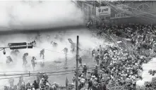  ?? REUTERS ?? Tear gas and fire extinguish­er gas float around demonstrat­ors during a protest against the military coup in Yangon, Myanmar, on Tuesday.