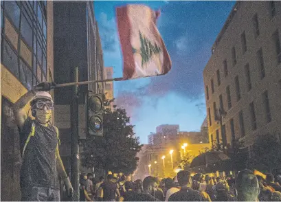  ?? DANIEL CARDE GETTY IMAGES ?? A protester waves the Lebanese flag Sunday near Martyrs’ Square in Beirut during protests urging political and economic reform.