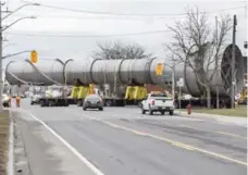  ?? GARY YOKOYAMA/THE HAMILTON SPECTATOR ?? A 10-storey smoke stack was escorted by police and utility workers as it made an eight-kilometre journey to ArcelorMit­tal Dofasco on Saturday.