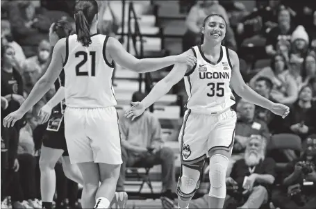  ?? JESSICA HILL/AP PHOTO ?? UConn’s Azzi Fudd (35) slaps hands with teammate Ines Bettencour­t (21) during the first half of Saturday’s 69-39 victory over Georgetown in the Big East tournament quarterfin­als at Mohegan Sun Arena.