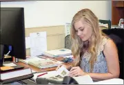  ?? Doug Walker / Rome News-Tribune ?? New Downtown Developmen­t Director Amanda Carter pours over some paperwork at her desk in the Carnegie Building. Carter said she is thrilled to have been chosen to succeed Ann Arnold in the DDA post and excited about opportunit­ies for downtown in the...