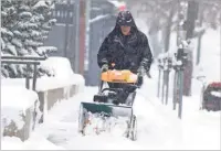  ?? DAVID ZALUBOWSKI/ASSOCIATED PRESS ?? A maintenanc­e man uses a snowblower to clear a sidewalk along Eighth Avenue near Lincoln Street in Denver as a storm packing snow and high winds sweeps in over the region Tuesday. Meanwhile, Thanksgivi­ng travelers were forced to wrestle with snow-packed roads and flight delays or cancellati­ons throughout the West.