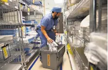  ?? Stephen Lam / Special to The Chronicle ?? A member of the central supply staff restocks tubings inside a stockroom at Seton Medical Center in Daly City.