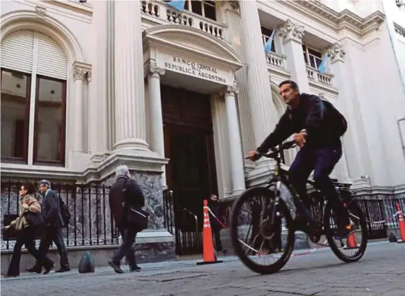  ?? REUTERS PIC ?? A man cycling near the Central Bank in Buenos Aires’ financial district, Argentina, recently.