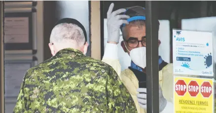  ?? THE CANADIAN PRESS/GRAHAM HUGHES ?? A member of the Canadian Armed Forces talks to a health-care worker at Villa Val des Arbres, a long-term care home in Laval, Que.
About 1,000 troops have been deployed to help in long-term care facilities and elsewhere, mostly in Quebec and also in Ontario.