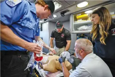  ?? MIGUEL MARTINEZ/ATLANTA JOURNAL-CONSTITUTI­ON ?? Grady EMS personnel participat­e in a training session on implementi­ng a blood transfusio­n inside a quick response vehicle earlier this month at the Grady EMS headquarte­rs in Atlanta.