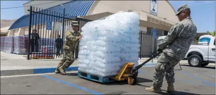 ?? JAMES QUIGG/THE DAILY PRESS VIA AP ?? National Guard members distribute free ice to residents in Trona, Calif., on Tuesday.