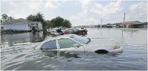  ?? GERALD HERBERT/THE ASSOCIATED PRESS ?? Flooded cars sit alongside a roadway in the aftermath of hurricane Harvey, in Port Arthur, Texas.