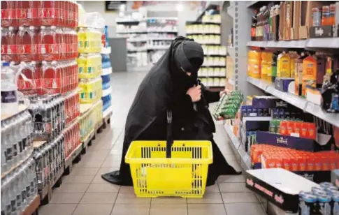  ?? REUTERS ?? Una mujer con niqab hace la compra en un supermerca­do de Copenhague