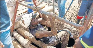  ?? /Reuters ?? Lifeline: A rescuer climbs up a shaft as retrieval efforts continue for trapped gold miners in Kadoma, Zimbabwe.