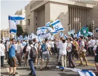  ?? (Sarah Levi) ?? PEOPLE WAVE FLAGS during the Jerusalem Day Parade last year.