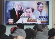  ?? AP ?? TV. La gente observa una pantalla de television en una estación de trenes en Seúl, que muestra a Donald Trump y al líder norcoreano Kim Jon un, en los extremos