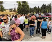  ?? DAN PELLE / THE SPOKESMAN-REVIEW ?? Parents gather in the parking lot behind Freeman High School in Rockford, Wash., on Wednesday to wait for their children after a deadly shooting at the high school.