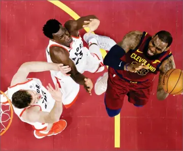  ?? AP PHOTO BY TONY DEJAK ?? Toronto Raptors’ Jakob Poeltl, left, and Pascal Siakam defend against Cleveland Cavaliers’ Lebron James during the first half of an NBA basketball game Wednesday, in Cleveland.