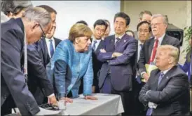  ?? NYT ?? German Chancellor Angela Merkel speaks to US President Donald Trump at the G7 meet as US national economic council director Larry Kudlow, UK Prime Minister Theresa May, French President Emmanuel Macron, Japanese Prime Minister Shinzo Abe, and US...