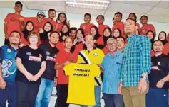  ??  ?? ABD Khadir (tengah) menyerahka­n baju T kepada atlet penembak Pahang yang menyertai SUKMA.