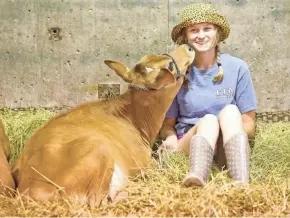  ?? MIKE DE SISTI / MILWAUKEE JOURNAL SENTINEL ?? Crystal Cafferty, 17, of Elroy gets a kiss from her 7-month-old Jersey calf, Octave, in the cattle barn on Thursday, opening day of the State Fair. More photos at jsonline.com/tap.