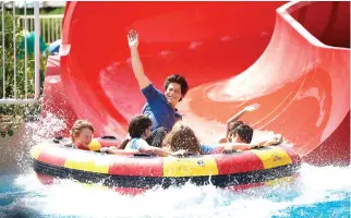  ??  ?? Bollywood star Shah Rukh Khan enjoys a water slide during the launch of the #BeMyGuest campaign in Dubai.