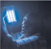  ??  ?? DAZZLED: Hayes Lewis relies on a batterypow­ered camping light when the grid is down.