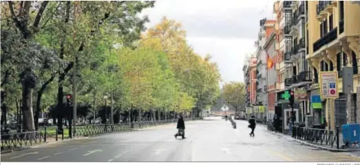  ?? FERNANDO ALVARADO / EFE ?? Dos personas cruzan una solitaria calle del centro de Madrid en la mañana de ayer, en un fin de semana largo con lunes festivo.