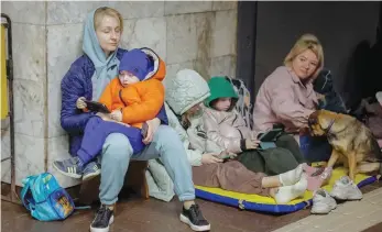  ?? — Reuters ?? People take shelter inside a metro station during a Russian missile strike in Kyiv on Thursday.