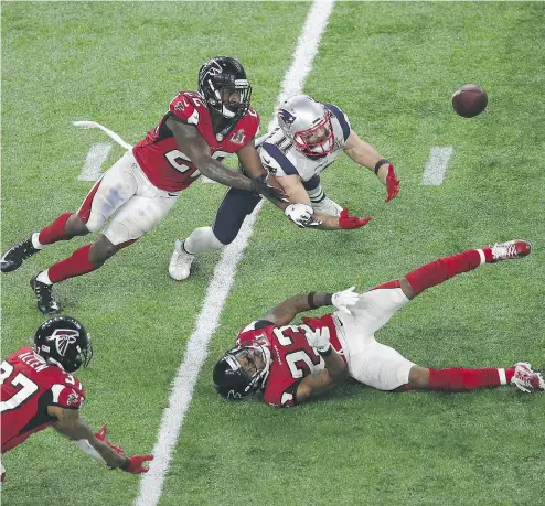  ?? EZRA SHAW / GETTY IMAGES ?? Julian Edelman of the New England Patriots makes a seemingly impossible 23-yard catch surrounded by three Atlanta Falcons’ defenders late in the fourth quarter of Super Bowl LI Sunday night in Houston.