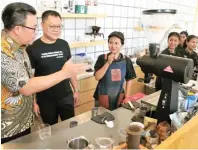  ?? FRIZAL/JAWA POS ?? KOMPETITIF: Daniel Ko (dua dari kiri) dan Tjahjono Haryono (kiri) berbincang dengan barista TGC Coffee di kawasan Basra, Surabaya, kemarin.