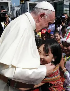  ??  ?? A young girl embraces Pope Francis as he arrives at Yangon Internatio­nal Airport in Myanmar yesterday. Photo: Reuters/Max Rossi