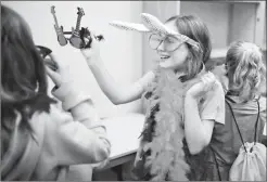  ?? Herald photo by Tijana Martin @TMartinHer­ald ?? Olivia Neufeld, 8, hands a pair of glasses to her friend during the phootshoot and photograph­y workshop as part of the GO Girl! event at Lethbridge College on Saturday.