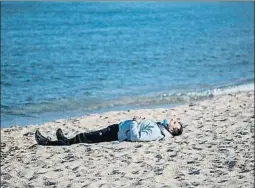  ?? EMILIO MORENATTI / AP ?? Un hombre descansa en la playa de Badalona