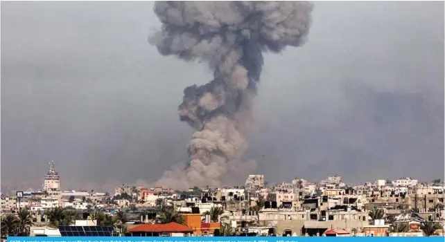  ?? — AFP photos ?? GAZA: A smoke plume erupts over Khan Yunis from Rafah in the southern Gaza Strip during Zionist bombardmen­t on January 8, 2024.