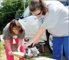  ?? Janelle Jessen/Herald-Leader ?? Youth Minister Amy Bennett and student Lydia Schallenbe­rg, 15, measured and sawed a board for Loretta Shoemaker’s back porch last week. Ozark Mission Project, a mission camp program for high school and college students sponsored by the United Methodist...