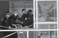  ?? ?? Police work near a broken glass door at the store’s entry. Officers opened fire when they saw someone being assaulted.