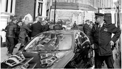  ?? AP PHOTOS ?? Police carry WikiLeaks founder Julian Assange from the Ecuadorian Embassy in London after he was arrested by officers from the Metropolit­an Police and taken into custody on Thursday, April 11.