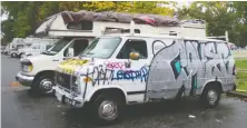  ?? MIKE BELL ?? RVS and vans are parked near the Strathcona Park encampment, where the city warned it will start enforcing its overnight parking ban.