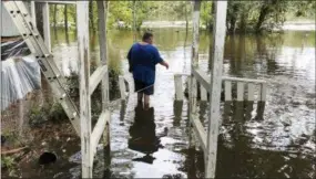  ?? JEFFREY S. COLLINS — THE ASSOCIATED PRESS ?? Shawn Lowrimore, son of Pastor Willie Lowrimore of The Fellowship With Jesus Ministries, wades into water near the church in Yauhannah, S.C., on Monday. The church is on the bank of the Waccamaw River, which is expected to keep rising for several days, forcing thousands of evacuation­s in the aftermath of Hurricane Florence.