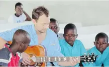  ??  ?? Country star Paul Brandt plays for kids in Repatriote.