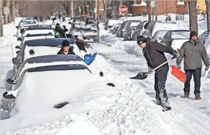  ?? BENNY SIEU/MILWAUKEE JOURNAL SENTINEL ?? People shovel out on Milwaukee’s east side on Feb. 2, 2011, after the city got more than 17 inches of snow. See more photos from the 2011 Groundhog Day Blizzard at