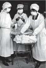  ??  ?? Nasen-Mund-Schutz gehörte bereits 1918 bei der Spanischen Grippe zur Basisausst­attung von Krankensch­western und Briefträge­rn.