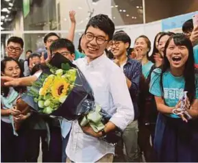  ?? [FOTO REUTERS] ?? Law (tengah) meraikan kemenangan selepas menang kerusi dalam pilihan raya perundanga­n di Hong Kong, semalam.