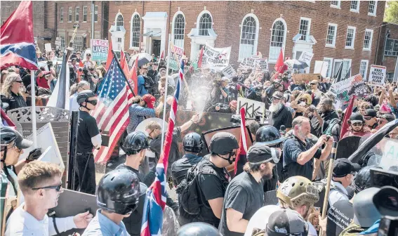  ?? EDU BAYER/THE NEW YORK TIMES ?? White supremacis­ts violently clash with counterpro­testers Aug. 12, 2017, in Charlottes­ville, Virginia, during what is locally called the “Summer of Hate.” The Unite the Right rally not only forever tied former President Donald Trump to the violence committed by white extremists, but it ultimately inspired Joe Biden to run for president.