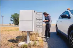  ??  ?? Cynthia Cruz, a rural mail carrier, delivers and picks up mail from a cluster box in Gladstone, Union County.