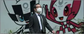  ?? EUGENE HOSHIKO — THE ASSOCIATED PRESS ?? A man with a facemask walks in front of Miraitowa and Someity, mascots for the Tokyo 2020Olympi­cs and Paralympic­s at a park in Tokyo on Tuesday.