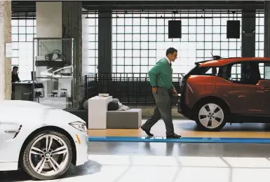  ?? Photos by Peter Earl McCollough / Special to The Chronicle ?? A customer buys a car at the BMW dealership in S. F. where the new zero- emission electric i3 is being sold.