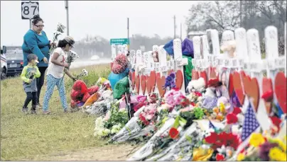  ?? AP PHOTO ?? Christina Osborn and her children Alexander Osborn and Bella Araiza visit a makeshift memorial for the victims of the shooting at Sutherland Springs Baptist Church, Sunday in Sutherland Springs, Texas. A man opened fire inside the church in the small...