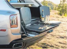  ??  ?? Beim noblen und teuren Rolls-Royce Cullinan lockt ledernes Gestühl zwei Personen auf den nach unten klappbaren Teil der Heckklappe. Dem stilvollen Picknick steht so nichts mehr im Wege.