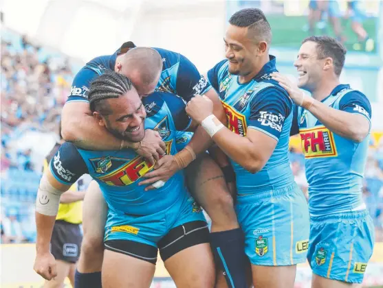  ??  ?? TOO EASY: Titans centre Konrad Hurrell celebrates a try with his teammates during yesterday’s clash against the Warriors at Cbus Super Stadium.