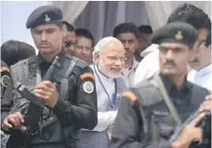  ??  ?? Modi (centre) is surrounded by commandos during an election campaign rally in support of the BJP candidate for Darjeeling constituen­cy, on the outskirts of Siliguri. — AFP photo