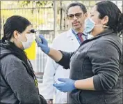  ?? Irfan Khan Los Angeles Times ?? LUCY ARIAS, right, with Dr. Oliver Brooks, checks a patient at Watts Health Center in South L.A. The center set up an outdoor COVID-19 screening station.